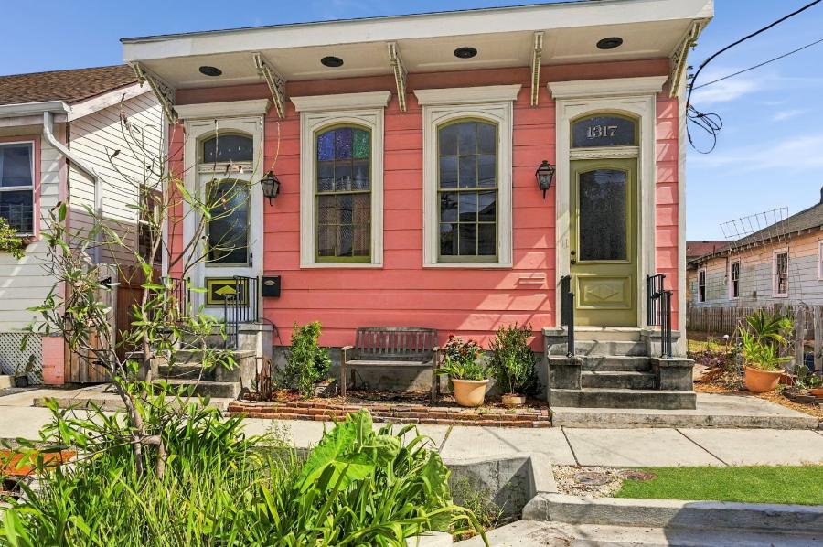 1317 Spain Street, a coral pink shotgun house with green doors in St. Roch, New Orleans