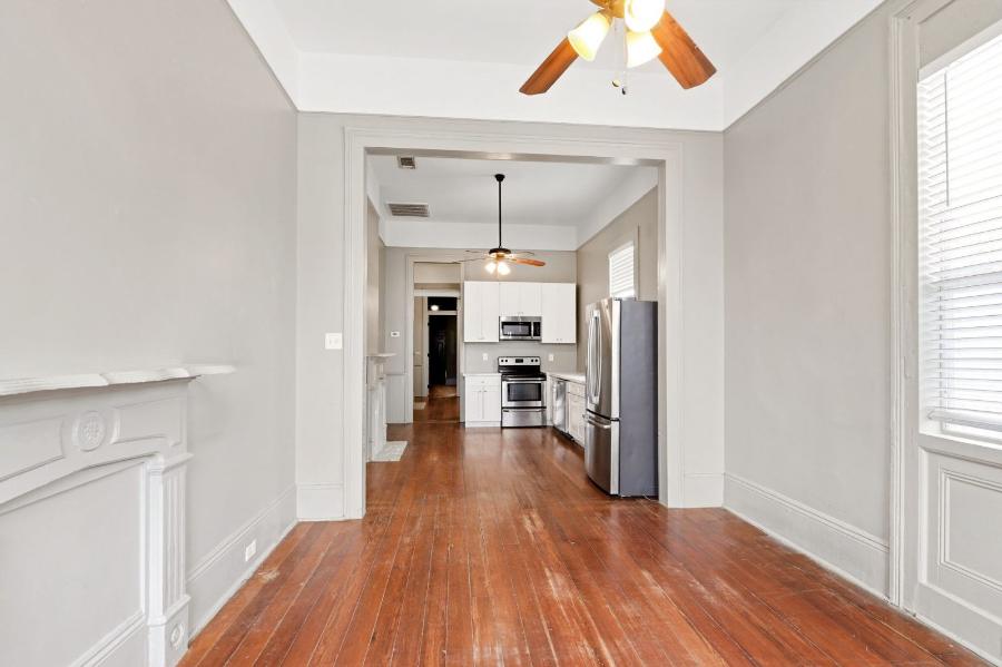 View through the rooms to the kitchen, showing 12-foot ceilings and hardwood floors