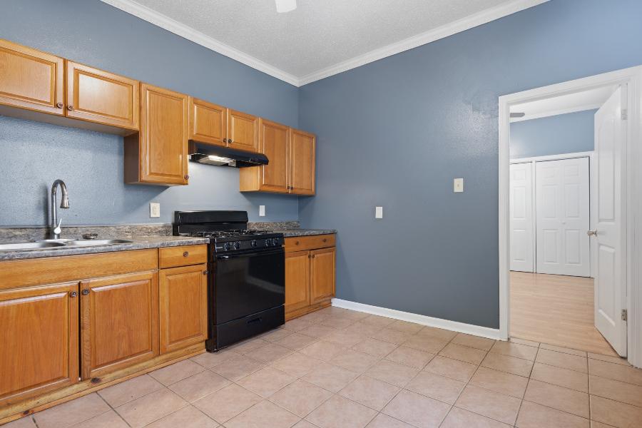 Kitchen counter and gas range with a doorway to the bedroom