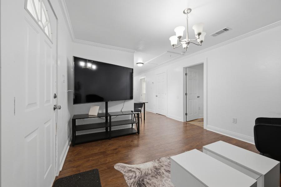 Living room with a large TV, looking toward the bedrooms