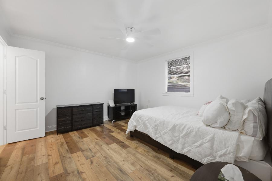 Bedroom with queen bed, dresser and TV